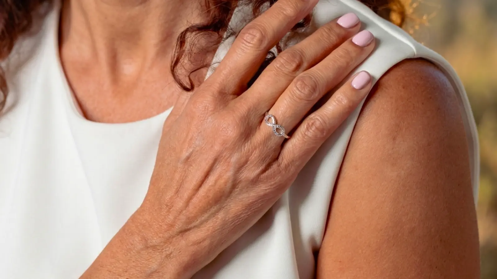 Close-up of a woman wearing a sparkling diamond infinity anniversary ring that symbolizes everlasting love, lifelong commitment, cherished memories, and the celebration of a meaningful wedding anniversary