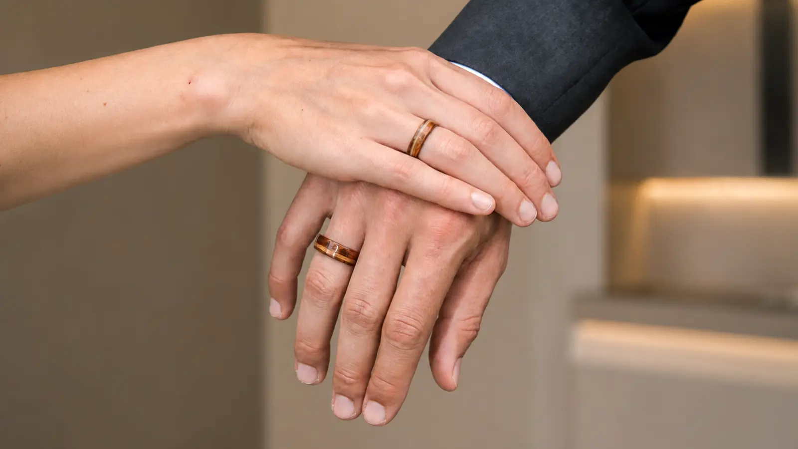 A couple wearing matching wooden wedding rings as a natural alternative to traditional metal bands