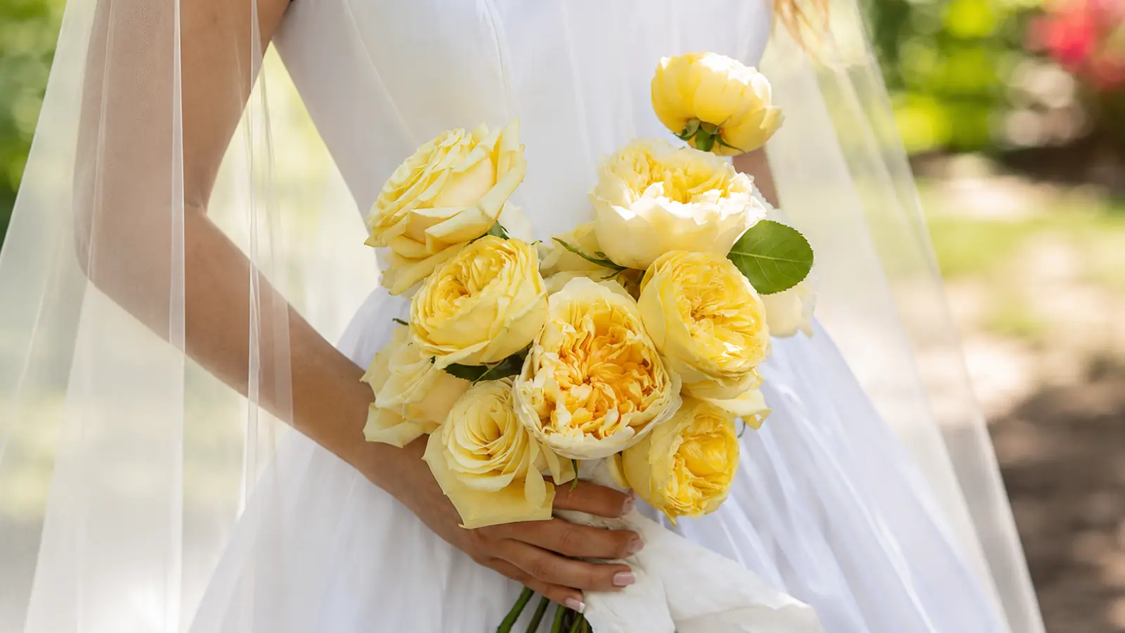 Bride holding a yellow rose wedding bouquets with garden roses and buttery yellow blooms Yellow Wedding Bouquets