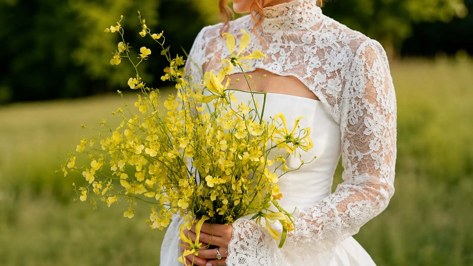 Bride holding a yellow wildflower wedding bouquet with dancing orchids and delicate blooms