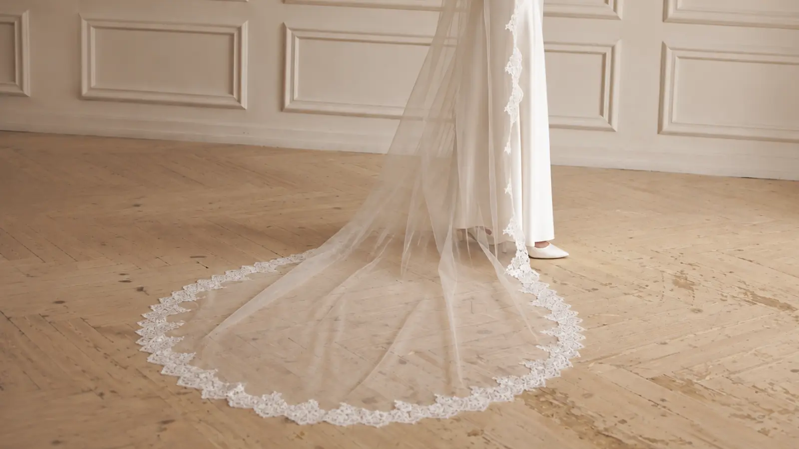 Bride wearing a chapel length wedding veil with detailed lace edging while holding a cascading bouquet of white and rust-colored flowers Chapel Length Wedding Veil