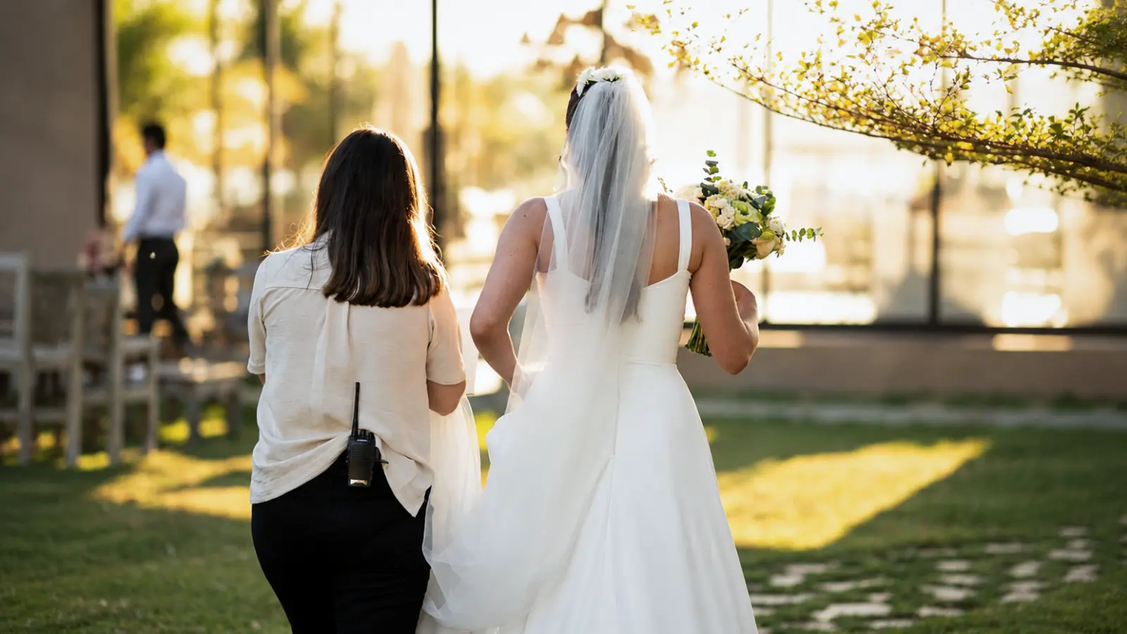 Wedding professional accompanying a bride before an outdoor ceremony, representing local and travel-in professionals hired for a destination wedding # Destination Wedding Vendors: How to Choose Local vs Travel-In Professionals