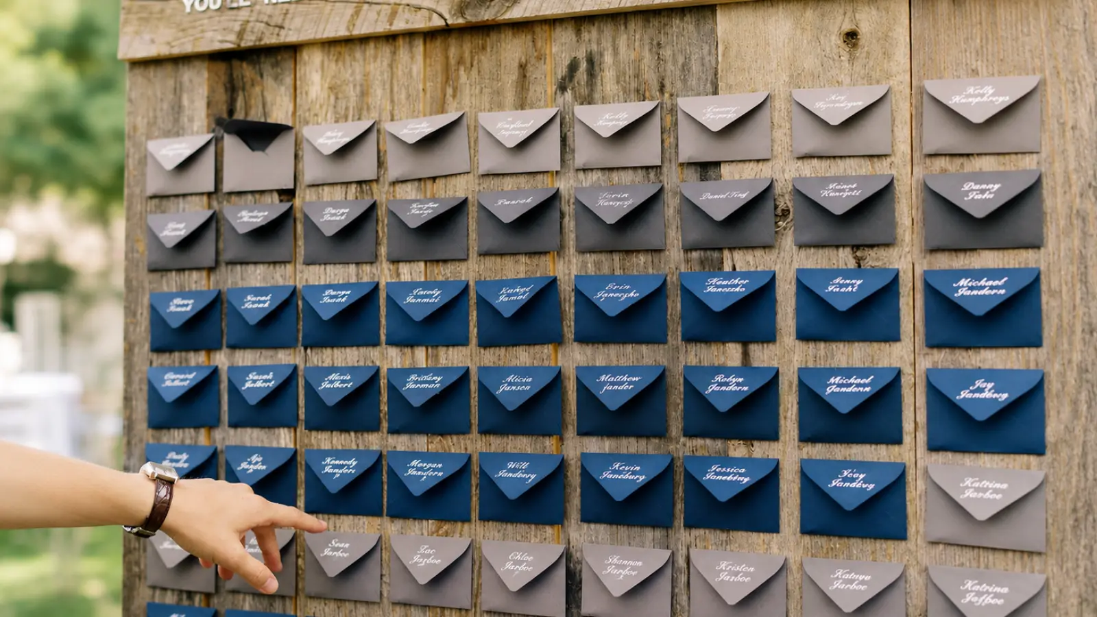 DIY Wedding Seating Chart with personalized envelopes arranged in rows on a rustic wooden board for guests to find their seating assignments DIY Wedding Seating Chart: Affordable Display Ideas That Work