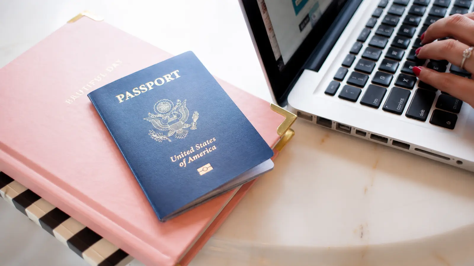 U.S. passport with travel documents and a laptop, illustrating legal requirements, documentation, recognition and filing considerations for getting married abroad Getting Married Abroad Legal Requirements: Documents, Recognition and Filing