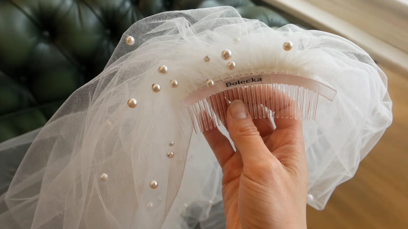 Finished DIY wedding veil with pearl details and attached comb showing gathered tulle and the completed attachment used to secure the veil