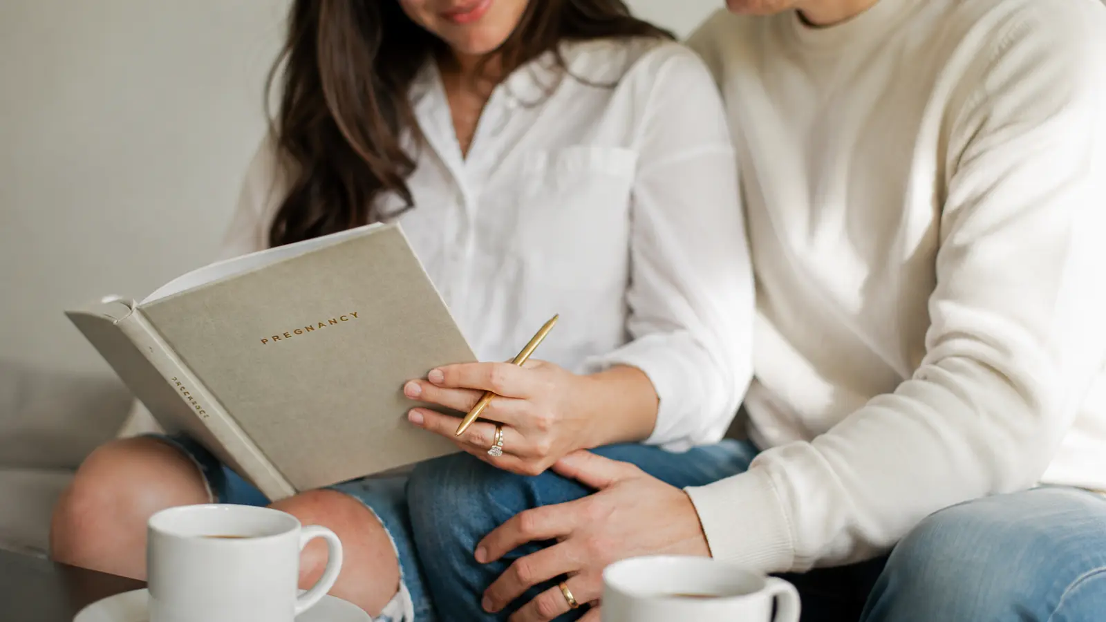 Engaged couple reviewing a planning notebook together while organizing their own wedding without the help of a professional wedding planner How to Plan Your Own Wedding Without a Wedding Planner