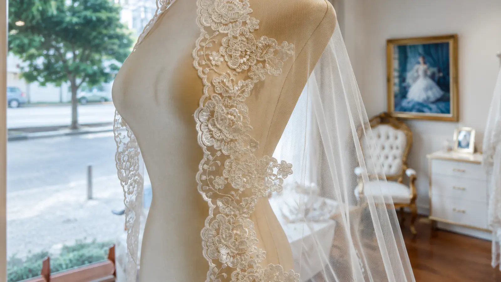 Wedding veil with an ornate floral lace border displayed on a dress form, showing how material quality and detailing can affect wedding veil cost
