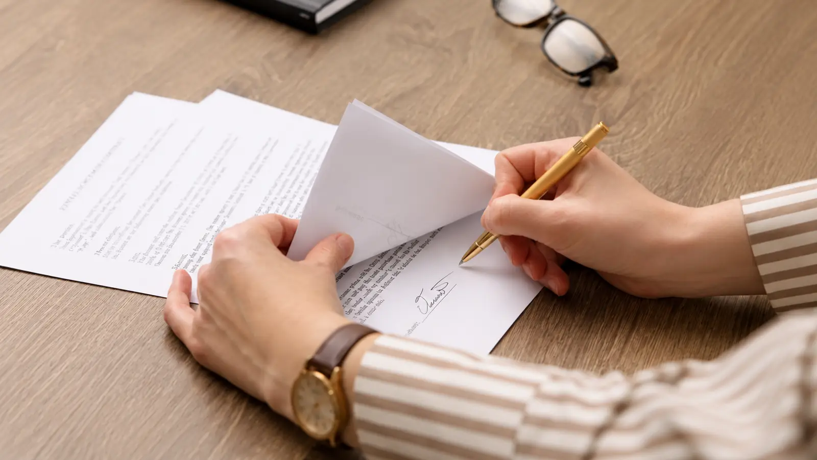 Newlywed signing official documents as part of the legal process to change a name after marriage How to Legally Change Your Name After Marriage