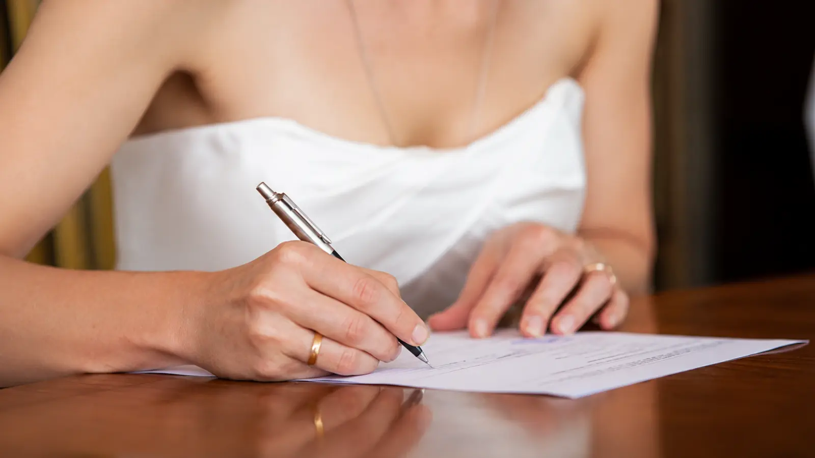 Bride signing official marriage documents related to marriage certificate authentication and apostille requirements for international use Marriage Certificate Apostille: Authentication for International Use