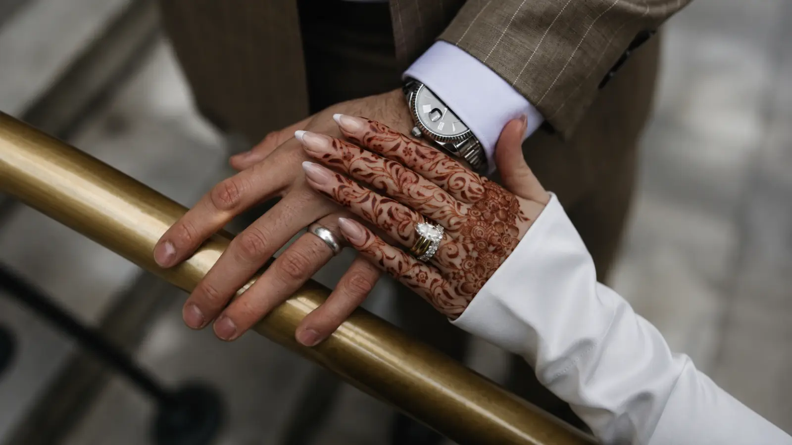 Multicultural wedding couple holding hands with intricate henna, engagement and wedding rings during their wedding celebration How to Plan a Multicultural Wedding That Feels Unified