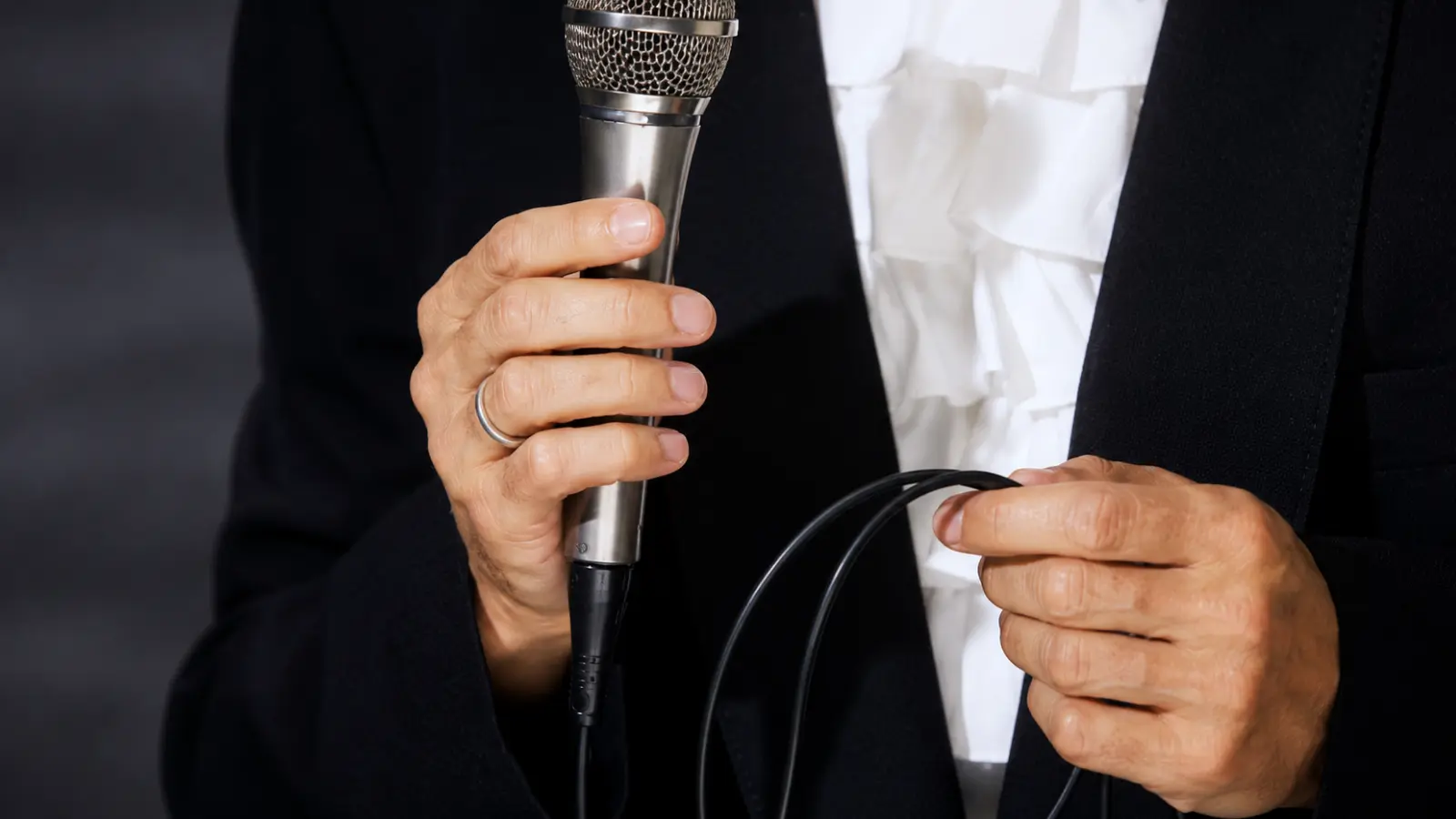 Ordained wedding officiant holding a microphone before a ceremony, illustrating officiant credentials, ordination and legal recognition for performing weddings Ordained Wedding Officiant: Meaning, Credentials and Legal Recognition