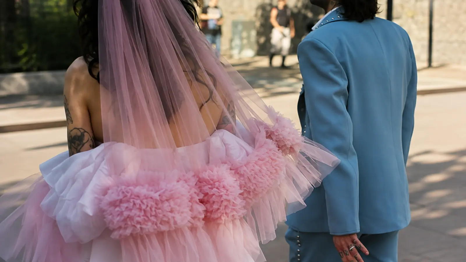 Bride wearing a pink colored wedding veil with a voluminous pink wedding dress featuring dramatic floral texture and layered tulle