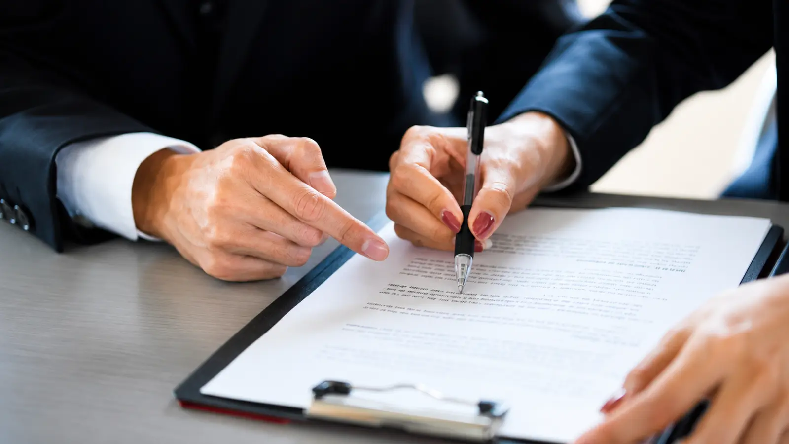 Couple reviewing and signing legal documents together as part of the prenuptial agreement process before marriage Prenuptial Agreement: What It Is, How It Works and What It Covers