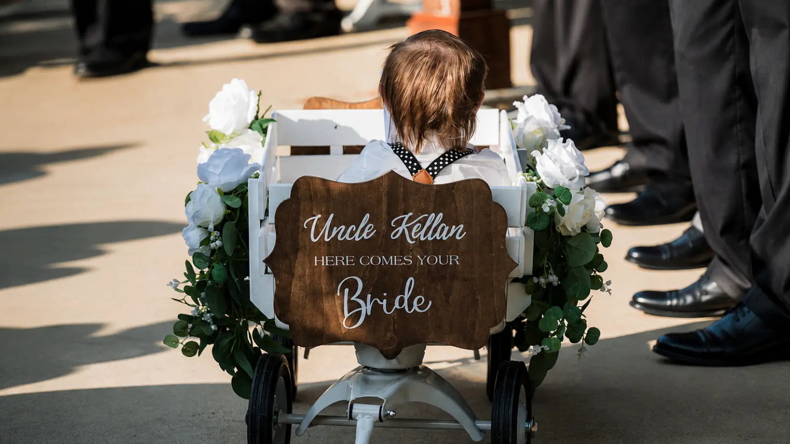 Young ring bearer rides in a decorated wedding wagon, illustrating a practical way for toddlers and very young children to participate in the processional