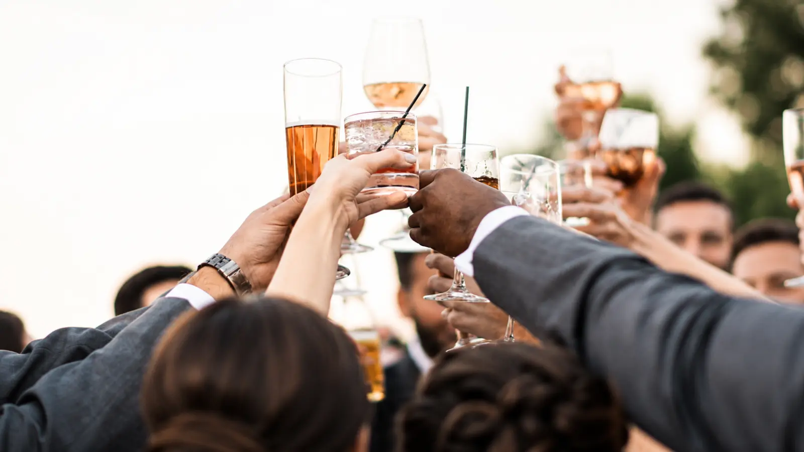 Wedding guests raising glasses together during the celebratory reveal of a surprise wedding