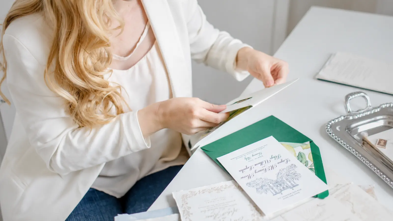 Wedding A-List and B-List planning represented by a woman reviewing invitations while organizing guest priorities and separate invitation waves Wedding A-List and B-List: How to Manage Invitation Waves