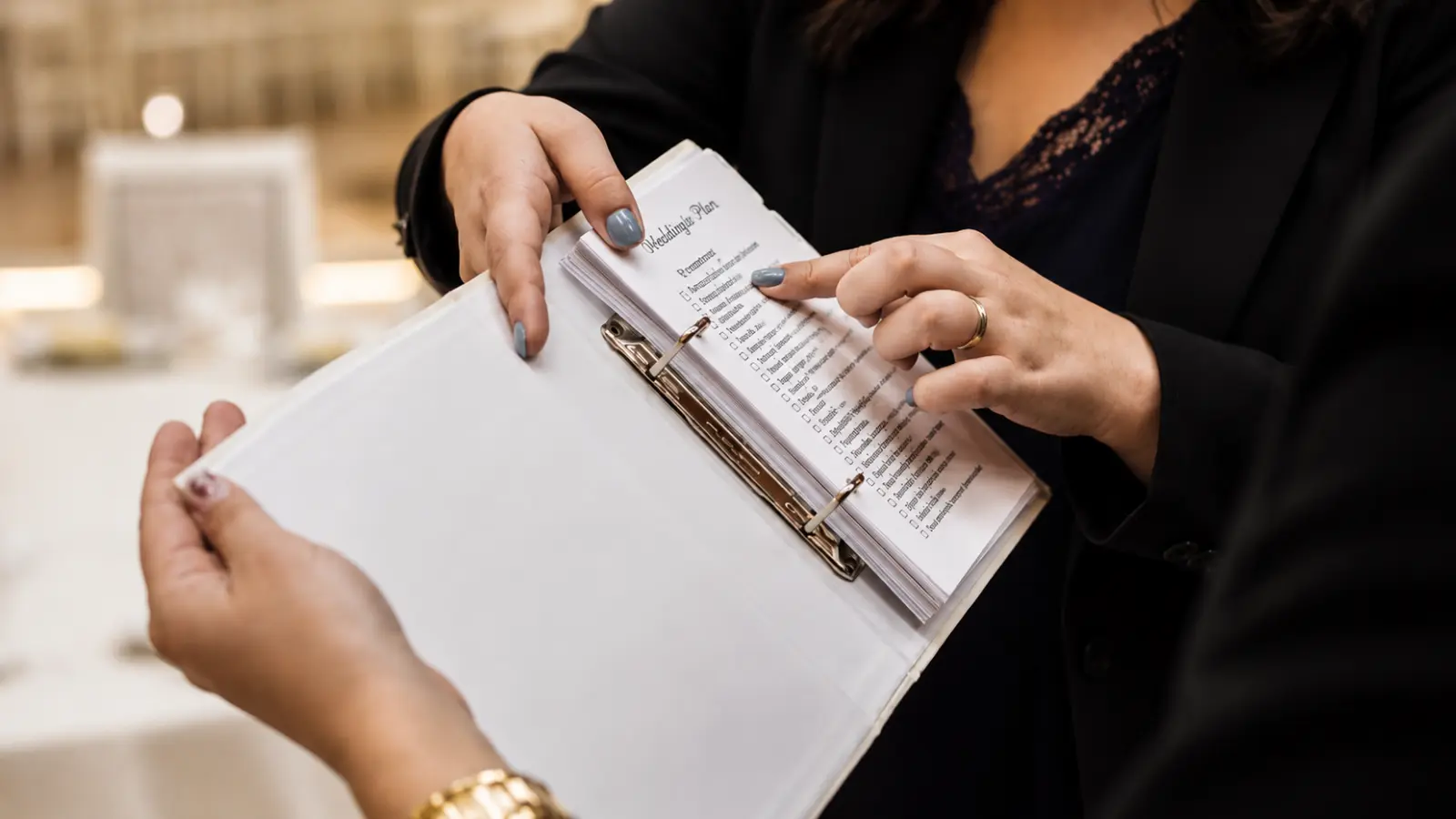 Wedding professional reviewing a ceremony checklist with a client while confirming final details and logistics before the wedding Wedding Ceremony Checklist: Everything to Confirm Before the Wedding