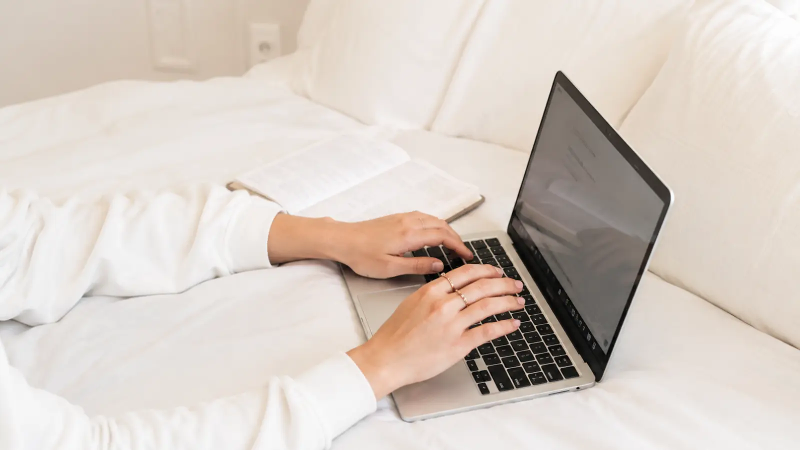 Wedding Guest List showing a couple using a laptop and planning notes to build, organize and finalize their list of wedding guests