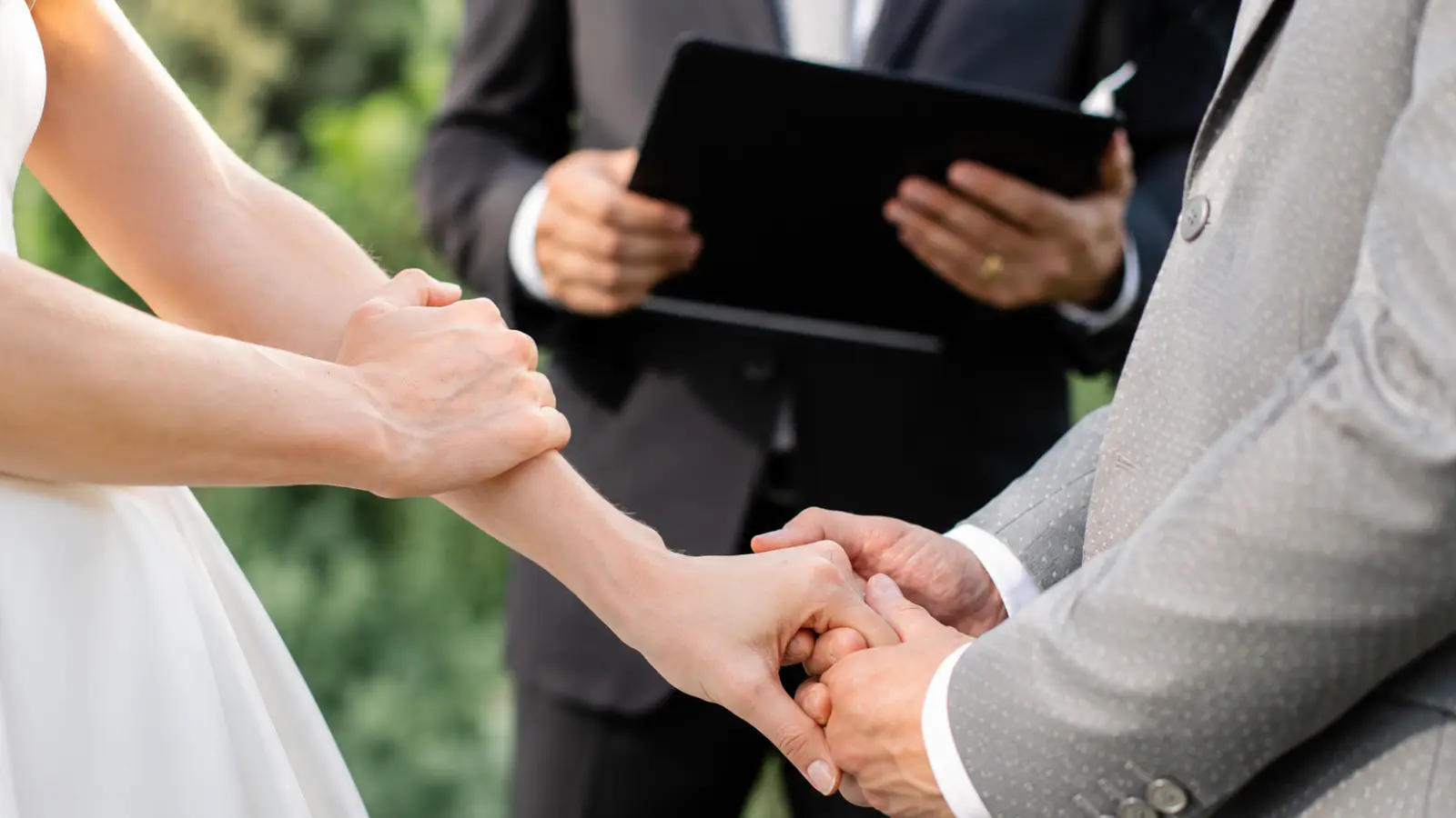 Wedding officiant conducting a marriage ceremony while the couple holds hands, representing officiant duties, legal responsibilities and how to choose one Wedding Officiant: What They Do, Legal Duties and How to Choose One