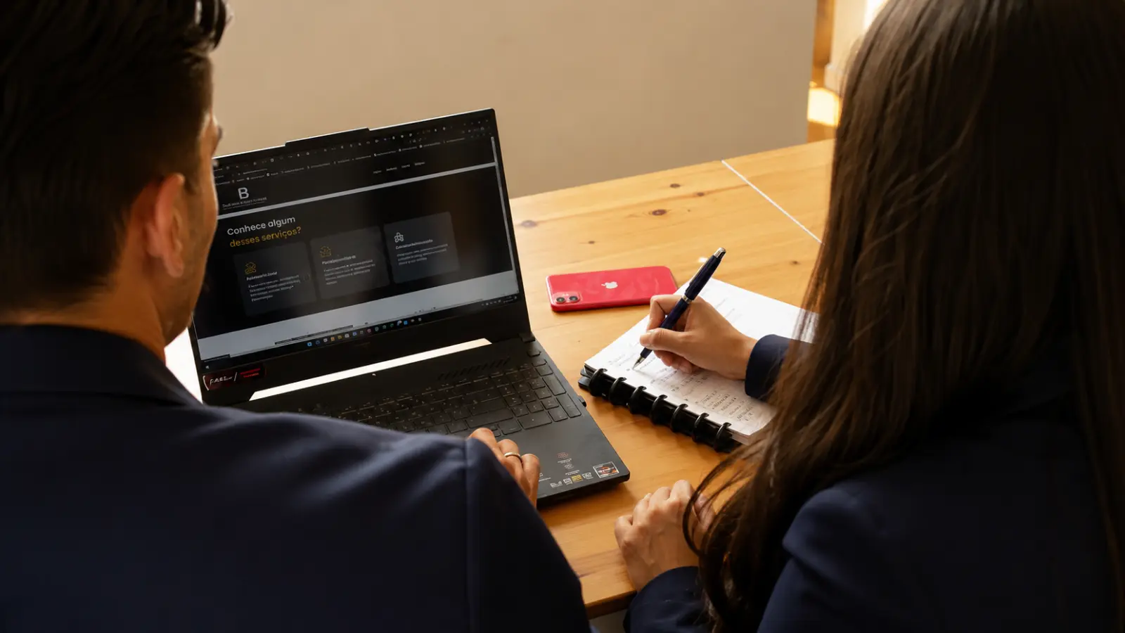 Couple using a laptop and notes together during a focused wedding planning meeting