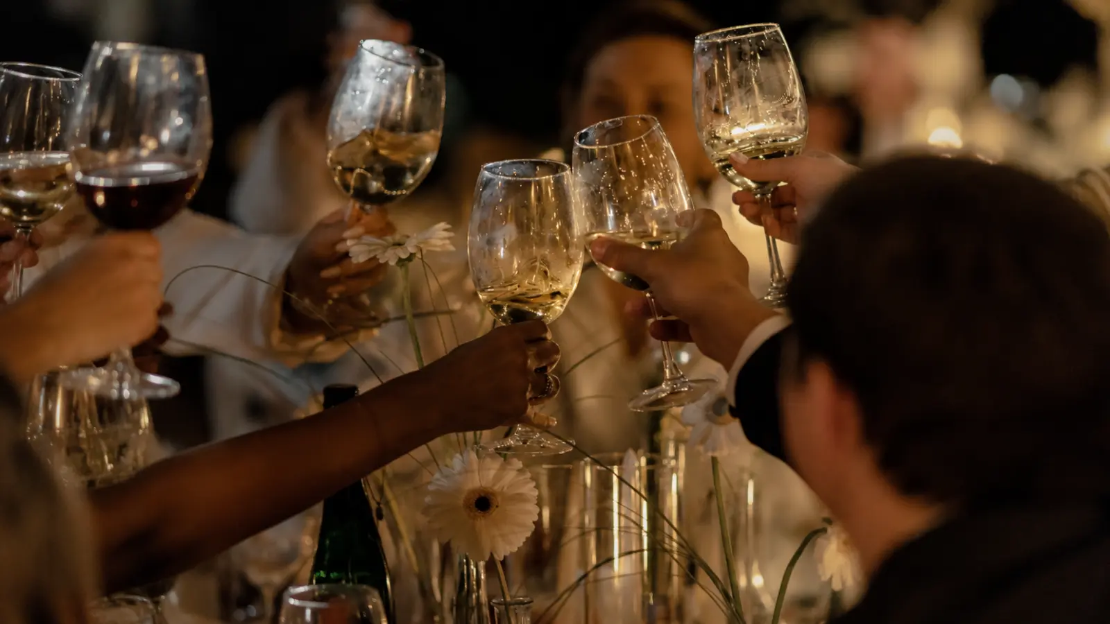 Wedding guests raising their glasses during a Wedding Reception Timeline, representing the scheduled flow of dinner, speeches, toasts, special dances, open dancing and other reception celebrations Wedding Reception Timeline: Dinner, Toasts, Dancing and More