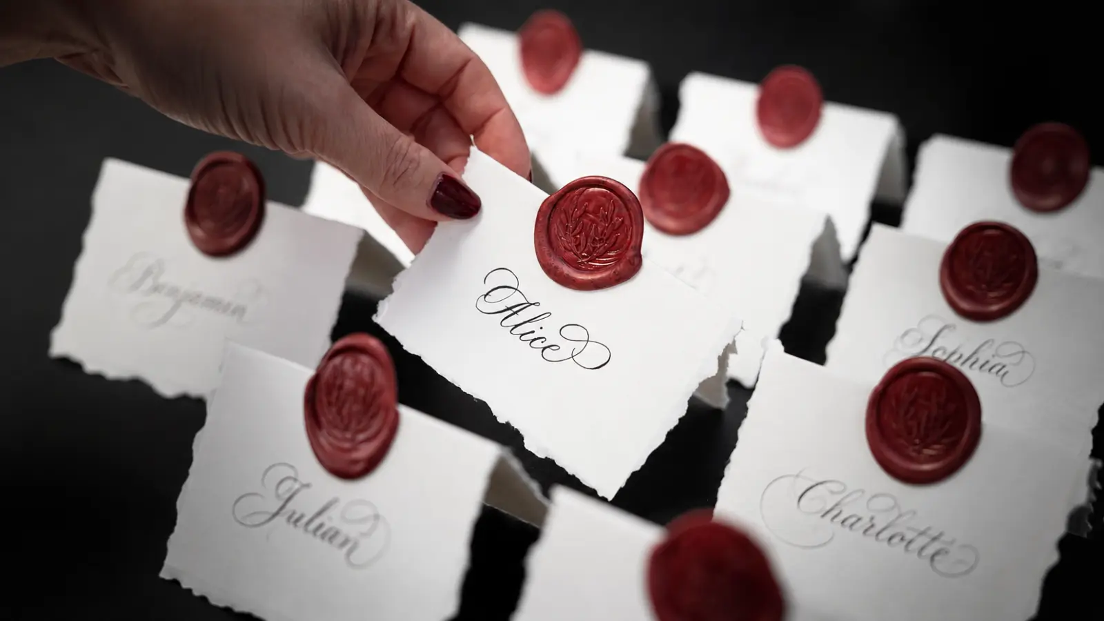 Wedding Seating Chart Template represented by personalized guest place cards with handwritten names and burgundy wax seals
