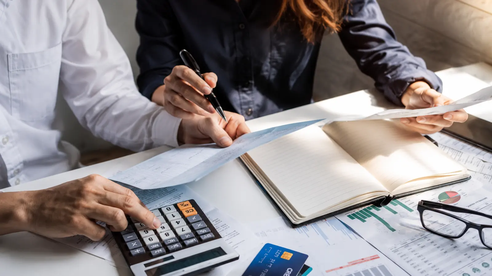 Wedding Vendor Payment Schedule being reviewed with invoices and a calculator to track deposits, balances and upcoming due dates Wedding Vendor Payment Schedule: Deposits, Balances and Due Dates