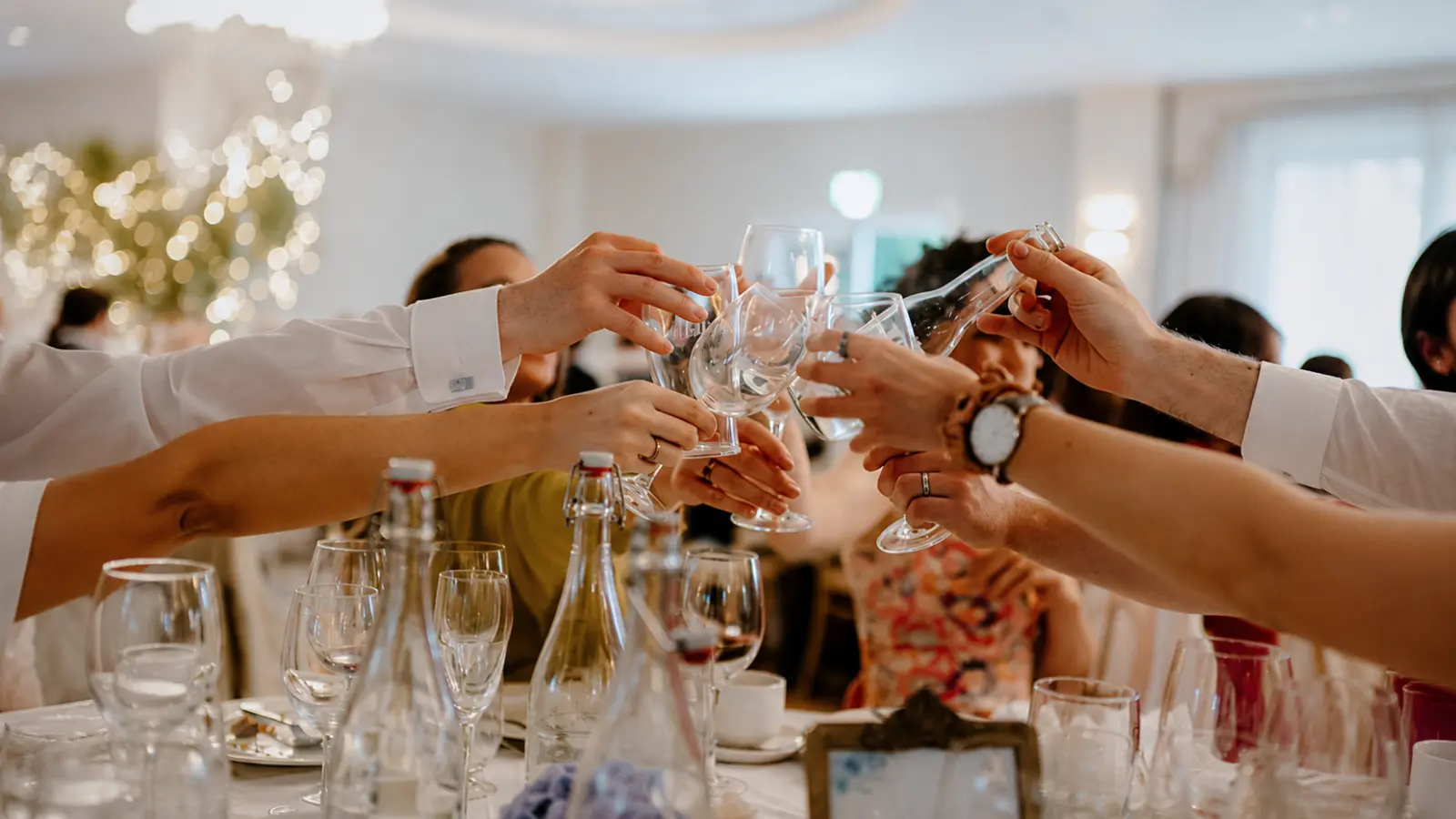 Wedding guests raising glasses together at the reception after completing the final week of wedding preparations