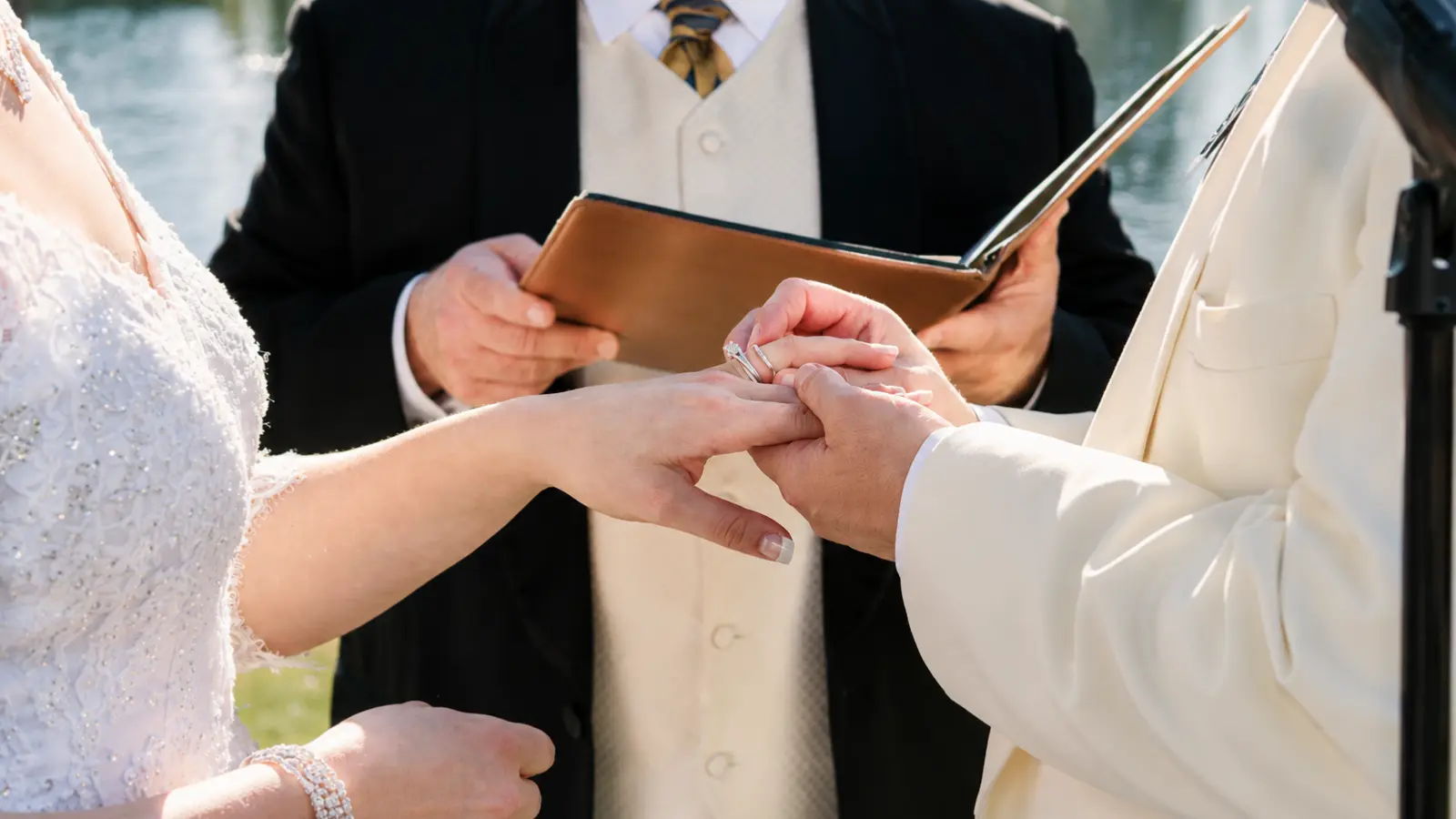 Wedding officiant overseeing a couple exchanging rings during a ceremony, representing legal roles, requirements and restrictions for officiating a wedding Who Can Officiate a Wedding? Legal Roles, Requirements and Restrictions