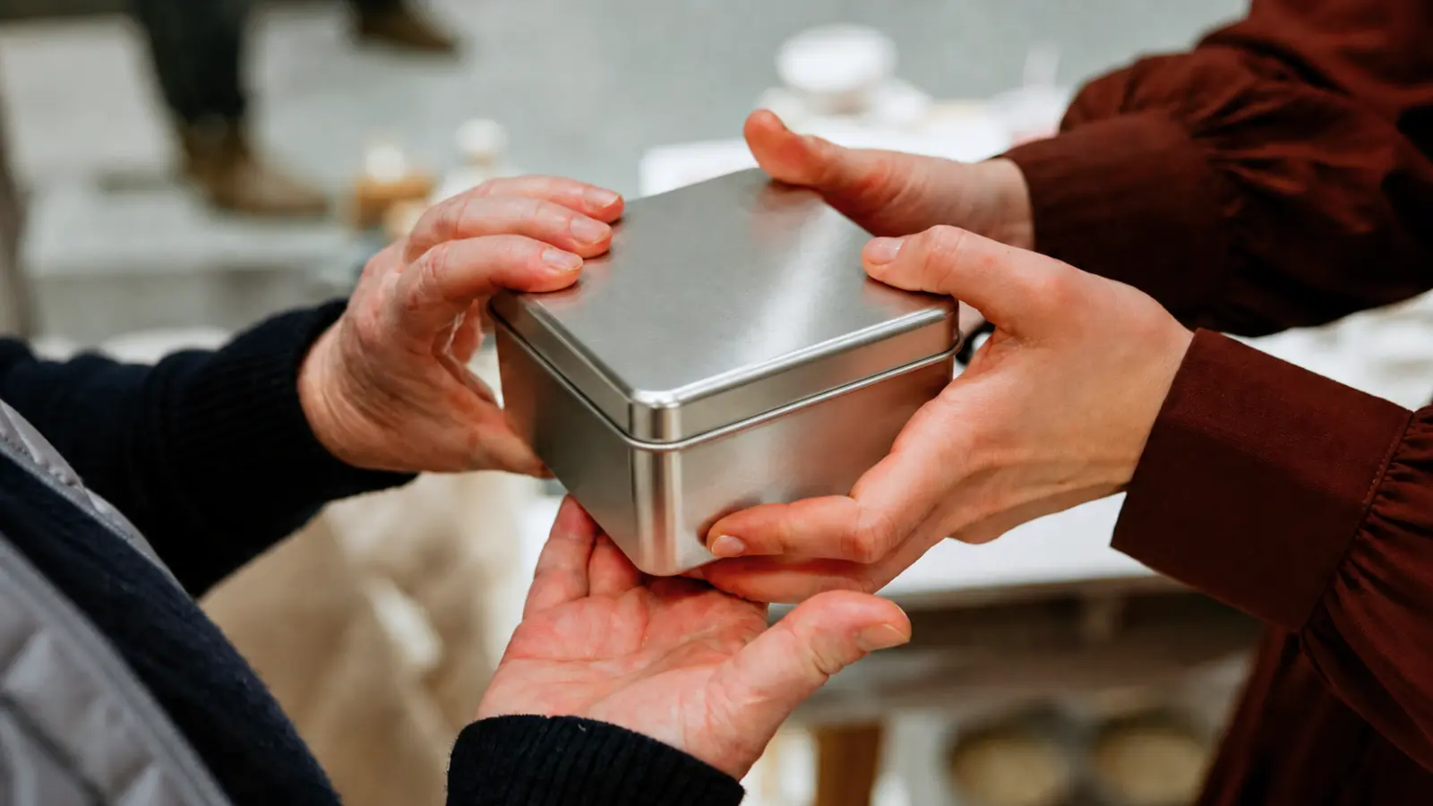 Metal tin gift box being exchanged as a traditional 10th wedding anniversary gift