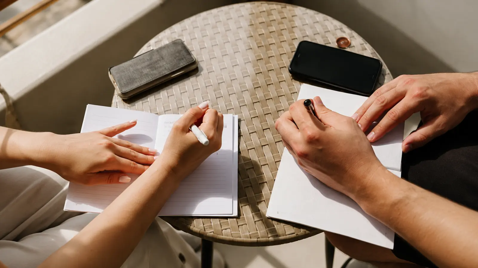 Couple writing personal letters to each other, illustrating a meaningful paper gift idea for celebrating their first wedding anniversary together