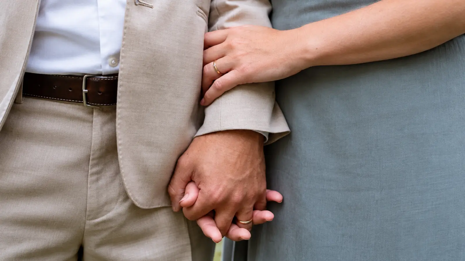 Married couple holding hands and wearing wedding rings, illustrating the lasting bond and strength associated with the fifth wedding anniversary 5th Wedding Anniversary Gift: Wood Ideas, Meaning and How to Celebrate
