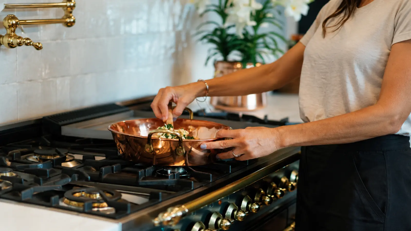 Woman cooking with a polished copper pan as a practical 7th wedding anniversary copper gift idea
