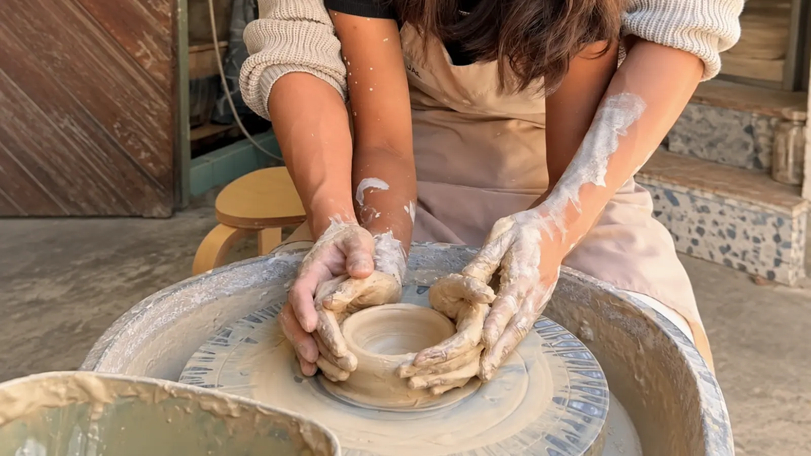 Potter shaping a handmade ceramic bowl on a pottery wheel as a traditional 8th wedding anniversary gift idea