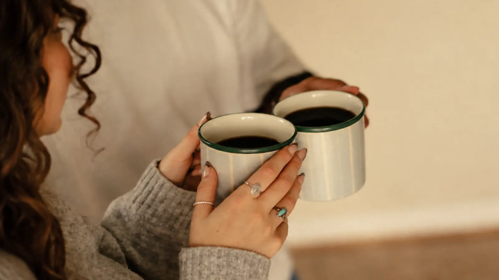 Couple holding matching ceramic mugs together as a practical pottery gift for an 8th wedding anniversary