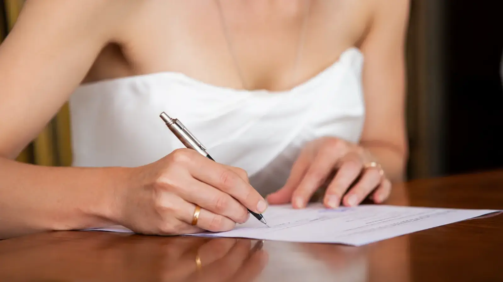 Bride signing marriage documents after the wedding ceremony