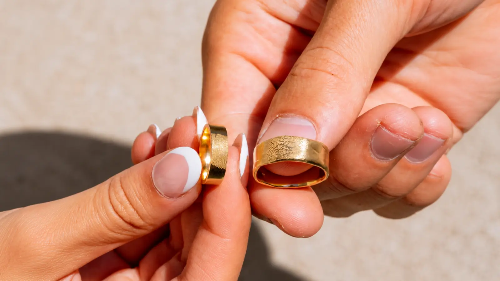 Gold wedding rings and bands worn by a couple