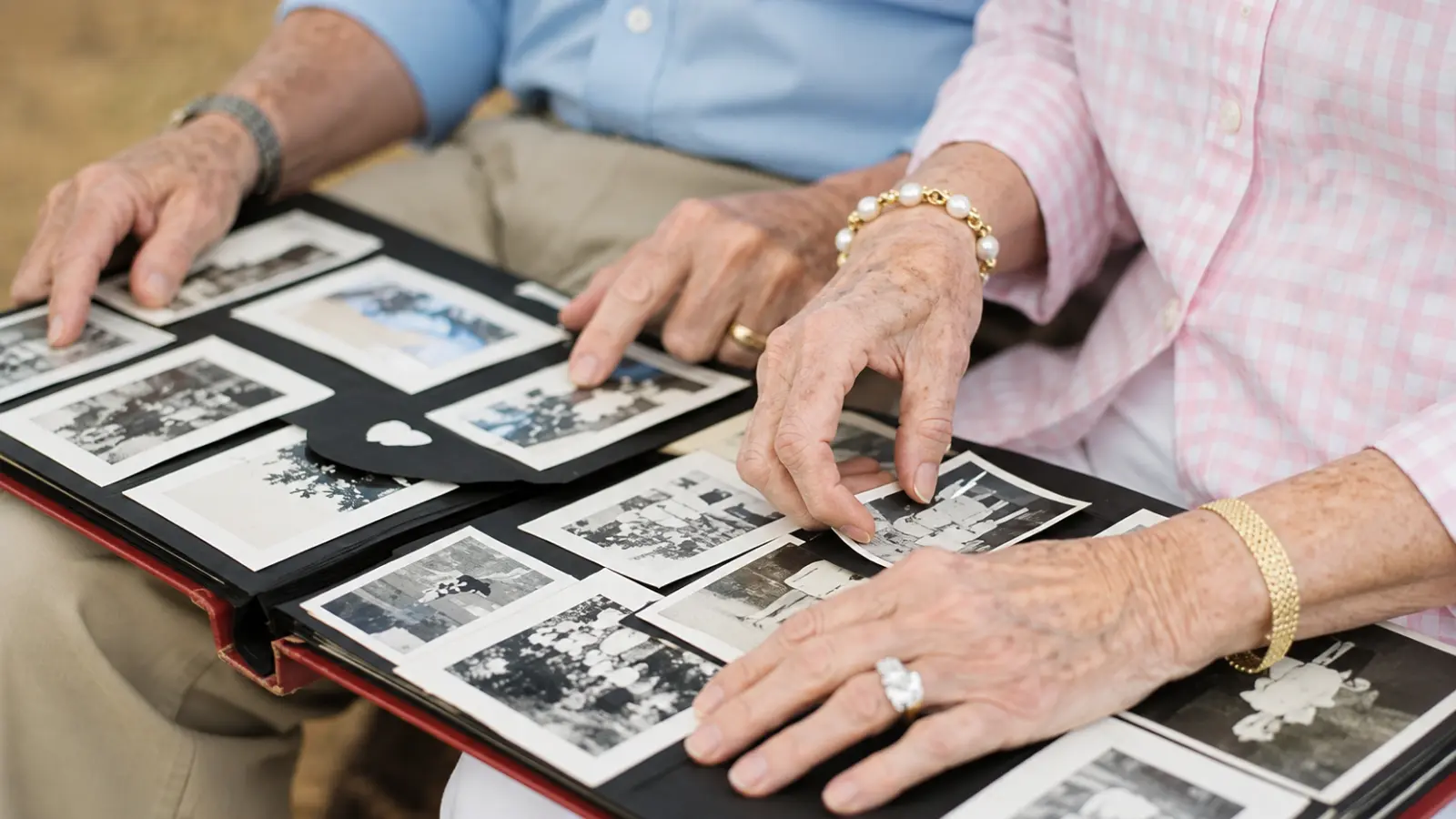 Older married couple looking through a photo album together, illustrating shared memories and the milestone years represented by traditional wedding anniversary names