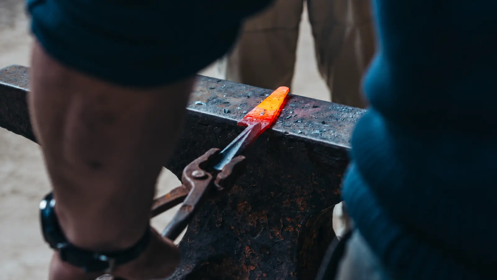Blacksmith working heated metal on an anvil for traditional 11th wedding anniversary steel gift inspiration