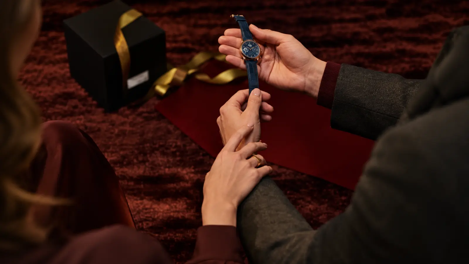 Couple looking at a wristwatch together as an 11th wedding anniversary gift idea