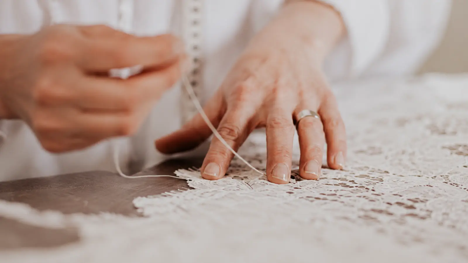 Hands making delicate lace as a traditional 13th wedding anniversary gift idea