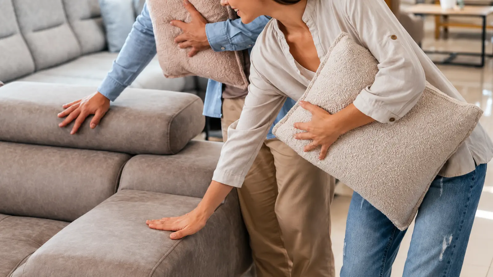 Couple choosing cushions for a living room sofa, representing furniture as the traditional 17th wedding anniversary gift theme